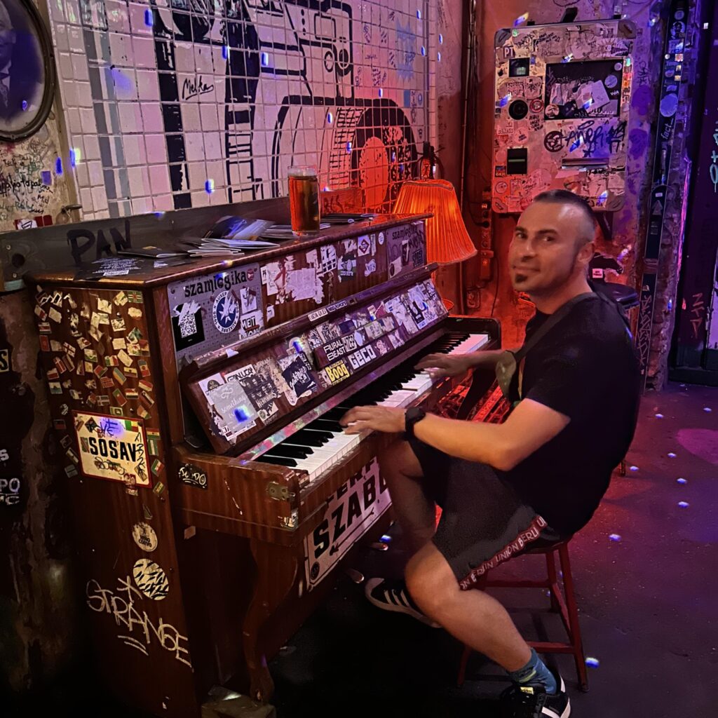 Nicki Smirnoff an einem alten akustischem Klavier mit sehr vielen Stickern.